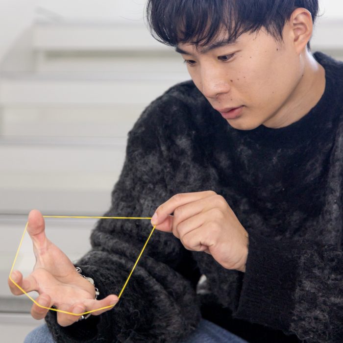 輪ゴムを見つめながら技法を研究する様子